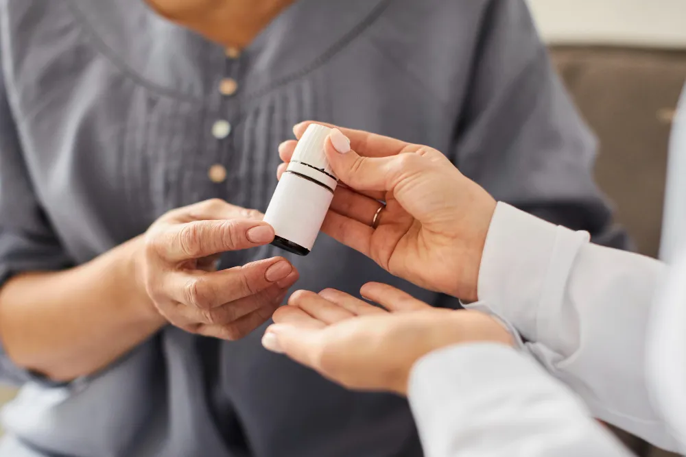 A doctor giving a medicine in glass bottle to her patient