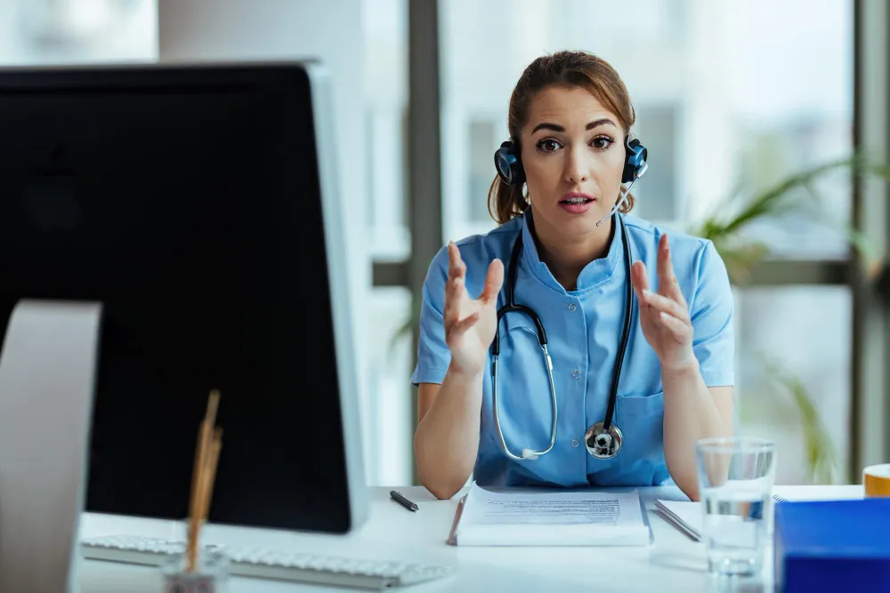 A doctor with the desktop system looking at front of the camera